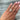 A close-up of a hand wearing a custom-made 14k gold 4.55 carat crisscut cushion lab grown diamond solitaire engagement ring